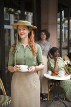 Load image into Gallery viewer, Woman in vintage attire holding a tea cup and saucer outdoors.