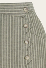 Load image into Gallery viewer, Close-up of a green striped fabric with buttons on a beige background