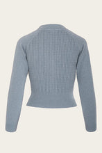 Load image into Gallery viewer, Blue knitted cardigan on a beige background