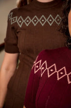 Load image into Gallery viewer, Close-up of a ribbed knit sweater with a geometric diamond pattern, shown in brown and burgundy colors on models.