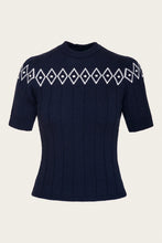 Load image into Gallery viewer, A navy blue short-sleeve knit sweater with a white geometric diamond pattern across the chest and shoulders, displayed on a neutral light beige background.