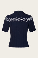 Load image into Gallery viewer, A navy blue short-sleeve knit sweater with a high mock neck and a white geometric diamond pattern across the shoulders, shown against a light beige background.