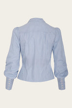 Load image into Gallery viewer, Blue and white striped shirt on a beige background