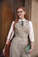 Load image into Gallery viewer, Woman in vintage attire with a vest and glasses, holding a folder and leather bag.