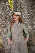Load image into Gallery viewer, Woman in vintage attire standing against a tree