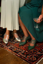 Load image into Gallery viewer, Two women seated on a patterned rug, shown from the knees down. One wears a light beige dress with shiny silver Mary Jane heels, and the other wears a deep teal dress with dark green Mary Jane heels while holding a cocktail glass.