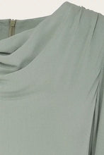 Load image into Gallery viewer, Close-up of a draped, cowl-neck top in a muted sage green color, showing the fabric texture and a zipper at the neckline.