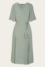 Load image into Gallery viewer, A sage green midi dress with a draped cowl neckline, short flutter sleeves, a matching tie belt, and tassel details, shown against a light beige background.