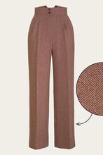 Load image into Gallery viewer, A pair of high-waisted, wide-leg trousers in a warm brownish-beige herringbone fabric, shown on a light beige background with a circular detail inset highlighting the texture.