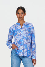 Load image into Gallery viewer, Woman wearing a blue floral blouse and jeans on a white background