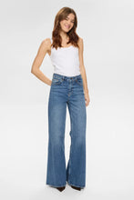 Load image into Gallery viewer, Woman wearing a white tank top and blue jeans on a white background