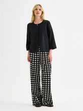 Load image into Gallery viewer, Woman wearing a black top and patterned pants on a white background