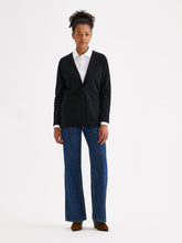 Load image into Gallery viewer, A model stands against a plain white studio background wearing a black knit blazer over a white collared shirt, blue wide-leg jeans, and brown shoes.