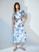 Load image into Gallery viewer, Woman wearing a blue and white floral dress against a white background