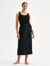 Load image into Gallery viewer, Woman wearing a black sleeveless top and black wrap skirt on a white background