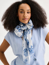 Load image into Gallery viewer, Woman wearing a blue floral scarf around her neck against a white background
