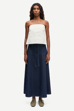 Load image into Gallery viewer, Woman wearing a strapless white top and navy blue skirt on a white background