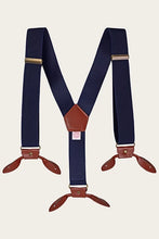 Load image into Gallery viewer, Navy blue canvas suspenders with brown leather clips and a brown leather center connector, displayed flat against a light cream background.