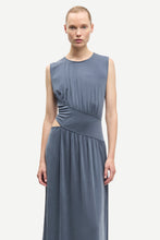 Load image into Gallery viewer, Woman wearing a sleeveless blue dress on a white background