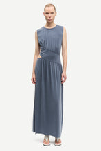 Load image into Gallery viewer, Woman wearing a sleeveless blue dress on a white background