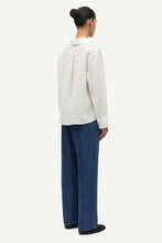 Load image into Gallery viewer, Person wearing a white blouse and blue pants on a white background