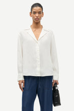 Load image into Gallery viewer, Person wearing a white blouse and blue pants holding a black bag on a white background
